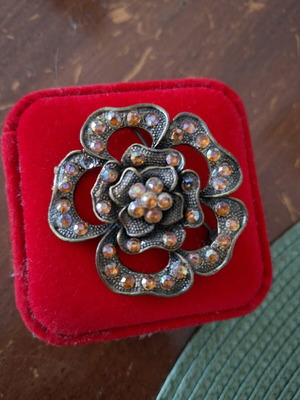 Flower brooch with orange crystals used