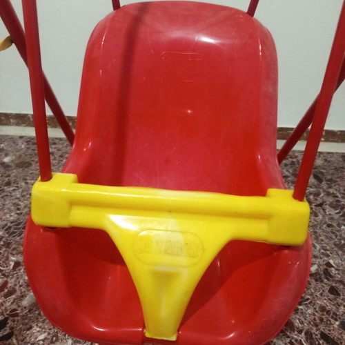 Child swing with metal frame and plastic seat, used with plastic wear