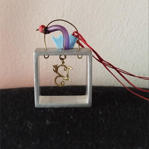 Sculpted pendant like new with square frame and red cord
