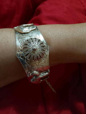 Βραχιόλι σαν καινούργιο με ιδιαίτερο κούμπωμα και ανάγλυφες παραστάσεις ασημί