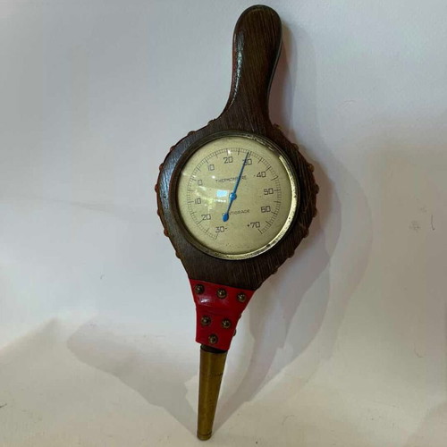 Vintage wall thermometer shaped like a fireplace bellows used