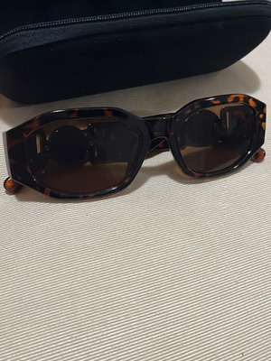 Sunglasses for daily use with black lenses and gold detail