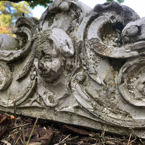 Old plaster pediment used with spiral motifs and human head