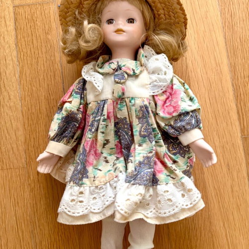 Porcelain doll like new with colorful dress and straw hat