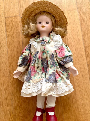 Porcelain doll like new with colorful dress and straw hat