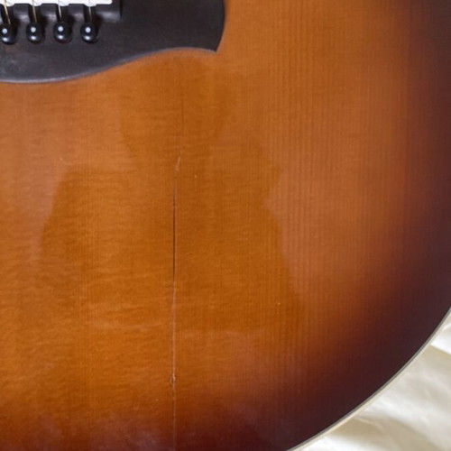 Ibanez folk acoustic guitar with crack on table