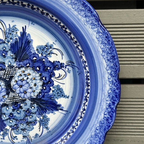 Handmade ceramic wall plate used with blue floral motif