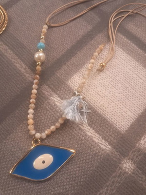 Long necklace with beads and metal eye decoration used