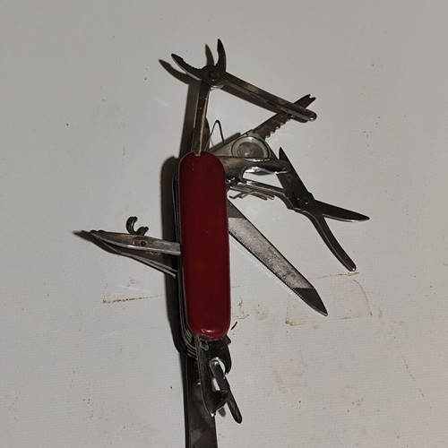 Multitool pocket knife used with red handle and multiple foldable tools
