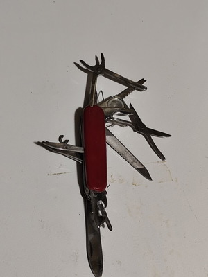 Multitool pocket knife used with red handle and multiple foldable tools