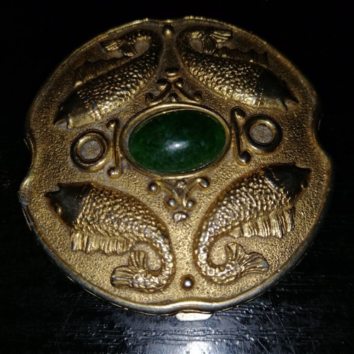 Vintage powder compact used with mirror and gold-plated box with emerald