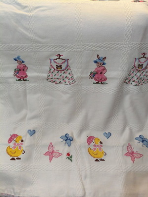 Handmade baby blanket with cross-stitch embroidery and lace used