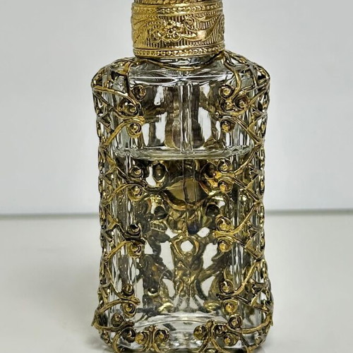 Vintage perfume flacon with filigree metalwork and red cabochon