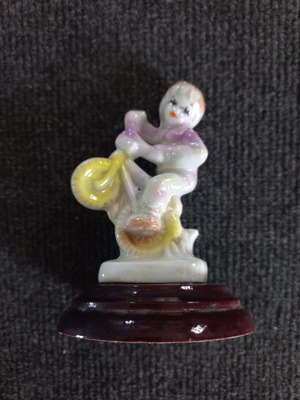 Porcelain figurine of a child on a bicycle