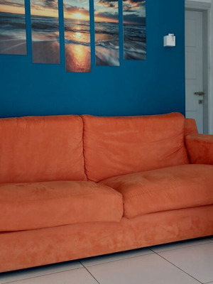 Three-seater sofa used, orange color with silver base