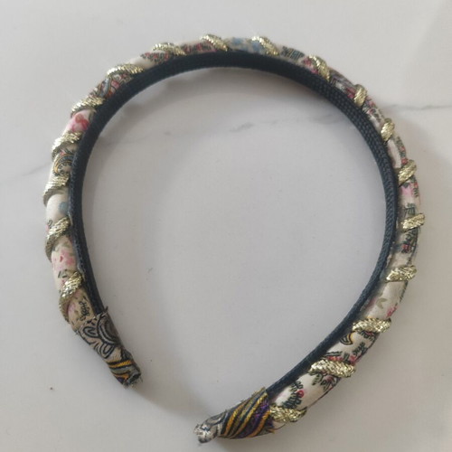 Headband with fabric floral design and gold braid used, abo