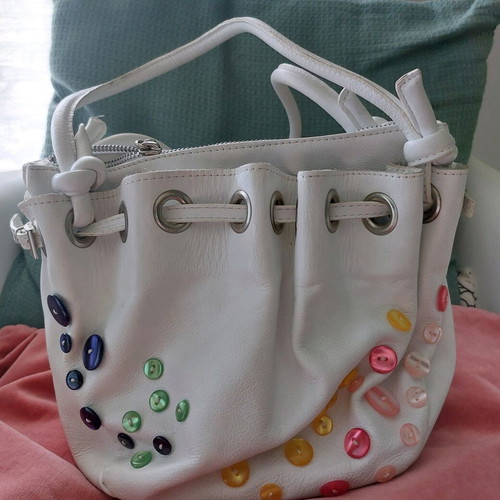 White bucket handbag used with decorative buttons