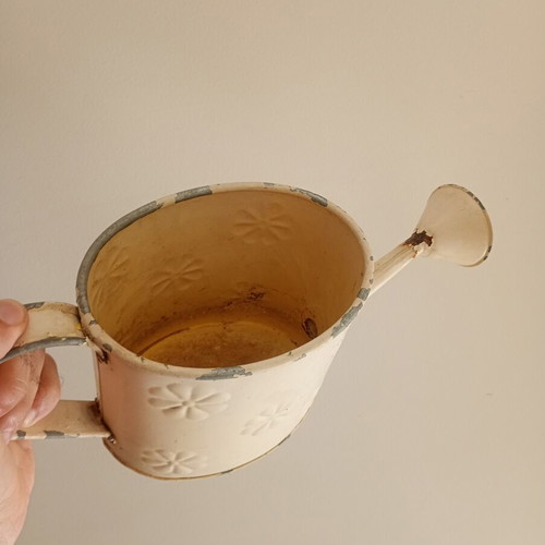 Vintage metal watering can with embossed design