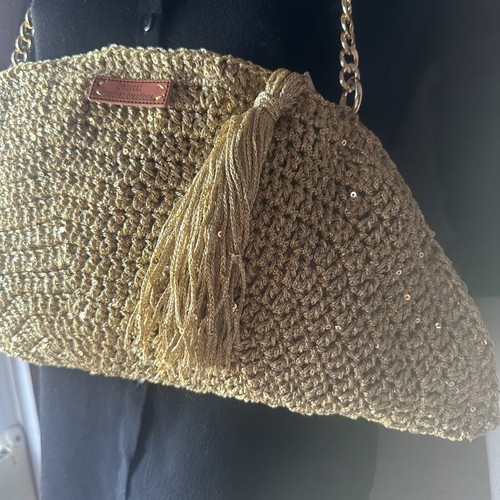 Handmade knitted shoulder bag in gold with decorative tassel