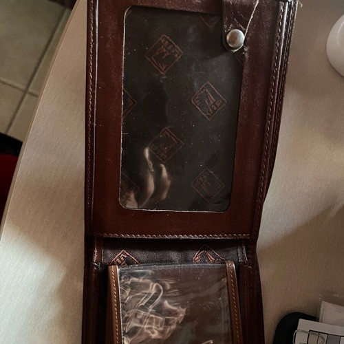 Brown wallet used with multiple card slots and belt-style clasp