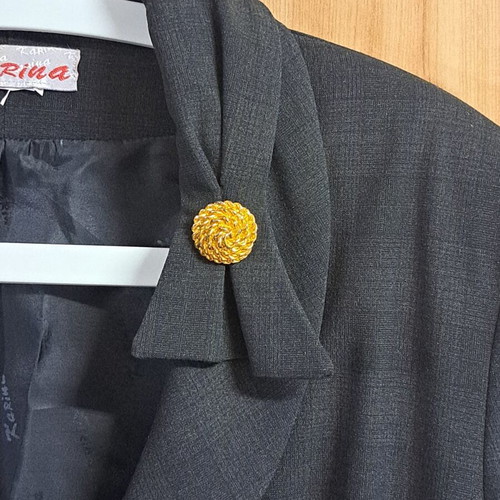 Women's black jacket with unique collar design and metallic detail