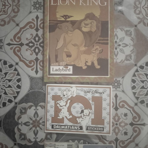 The Lion King small children's book in English and partially completed Dalmatians stickers
