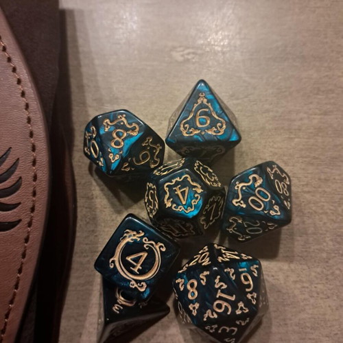 Brown leather dice bag with green D&D dragon dice