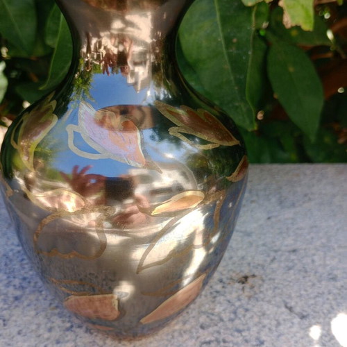 Intricately enameled brass vase with flowers.