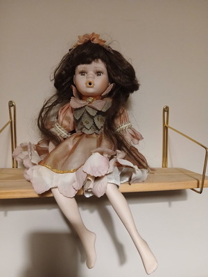 Porcelain doll sitting pose