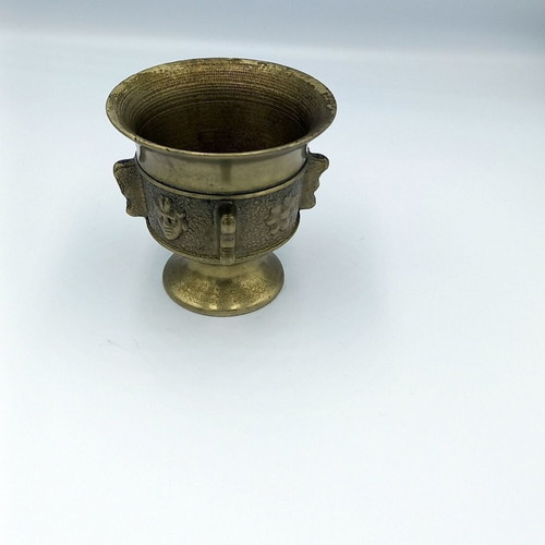 Metal mortar used with face and plant decoration
