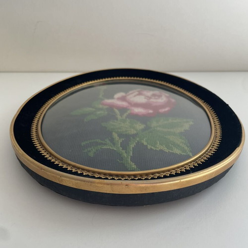 Embroidery frame with rose on black background