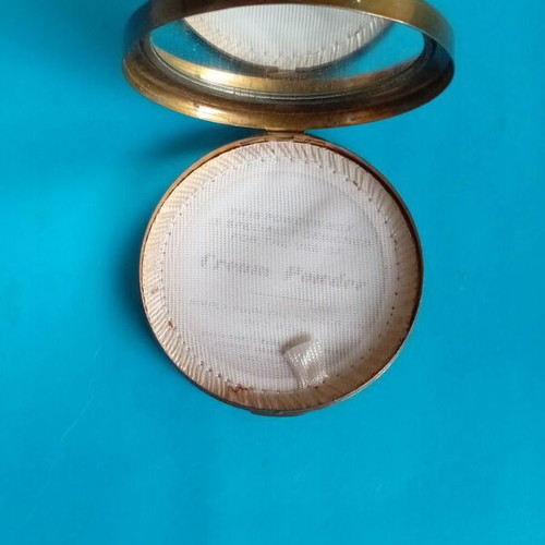 Antique powder compact used with metal bronze casing
