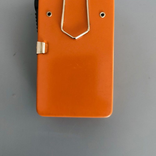 Vintage orange flat pocket flashlight used with retro UCAR battery