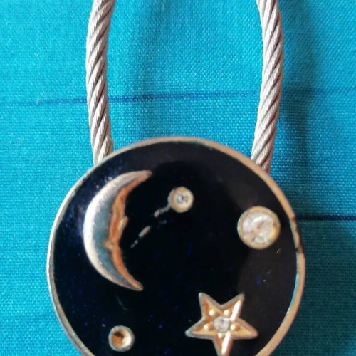 Keychain with moon and star design used, blue and silver