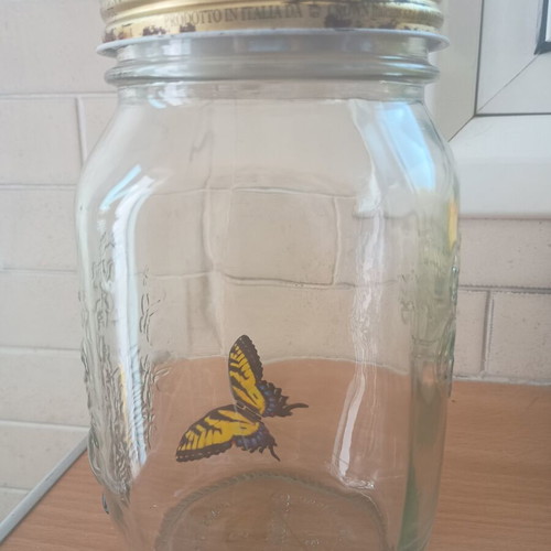 Decorative jar with moving butterfly mechanism