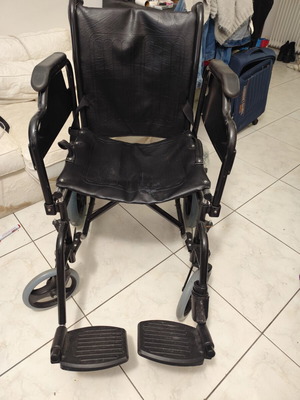Manual wheelchair used with rear wheel brakes and belt