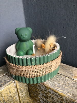 Bear candle in plaster jar with dried flowers, new