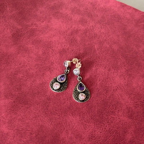 Silver earrings used with purple stones
