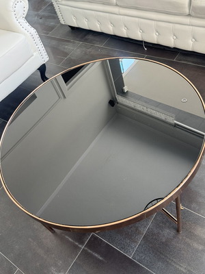 Round coffee table with glass top and metal frame