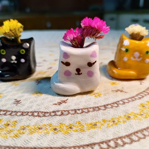 Decorative clay cat figurines with dried flowers