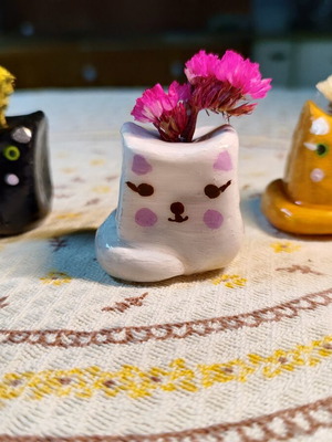 Decorative clay cat figurines with dried flowers