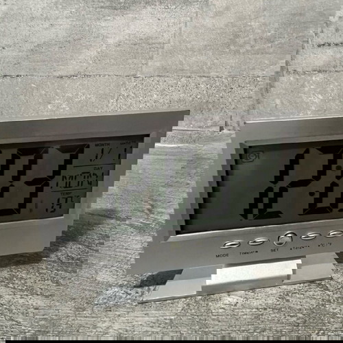 Digital table clock used with alarm and thermometer