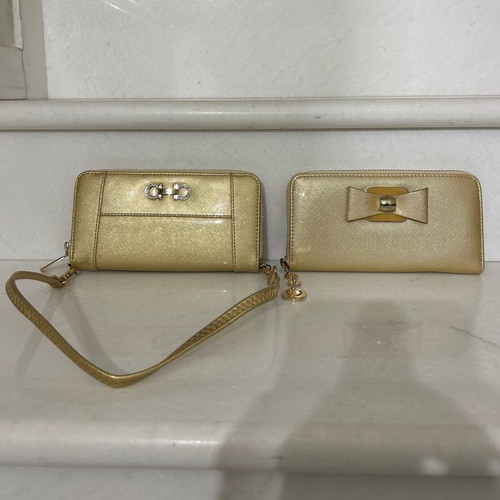 Two gold wallets, one with wrist strap