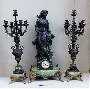 Ρολόι μεταλλικό με άγαλμα κοπέλας, μαρμάρινη βάση και δυο πεντάκερα κηροπήγια.