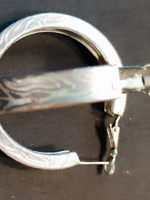 Metal hoop earring like new, silver with embossed design