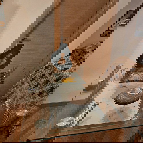 Γυάλινη τραπεζαρία σαν καινούργια με μεταλλικά πόδια και διακοσμητικό ράφι