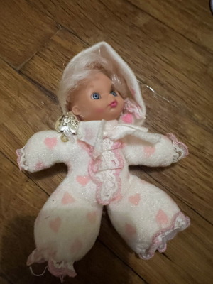 Doll with hood, missing one leg and one arm, slight tear