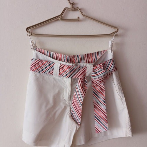 Red sleeveless blouse like new with white shorts and striped belt