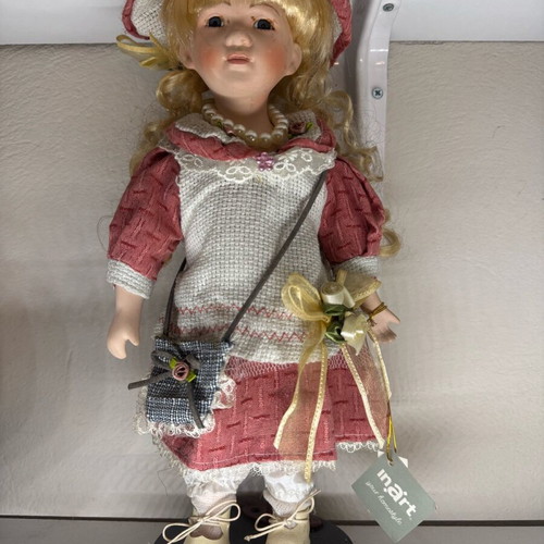 Porcelain doll new with tag and base