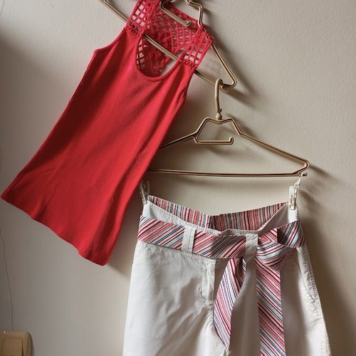 Red sleeveless blouse like new with white shorts and striped belt